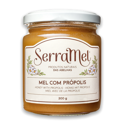 A jar of SerraMel honey with propolis, labeled 300g, with a predominantly yellow label and a white background.